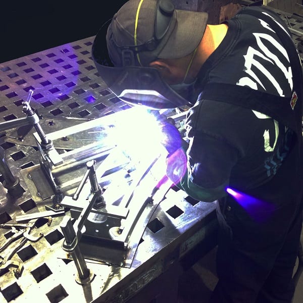 A welder creating a custom TK6 truss curve section.